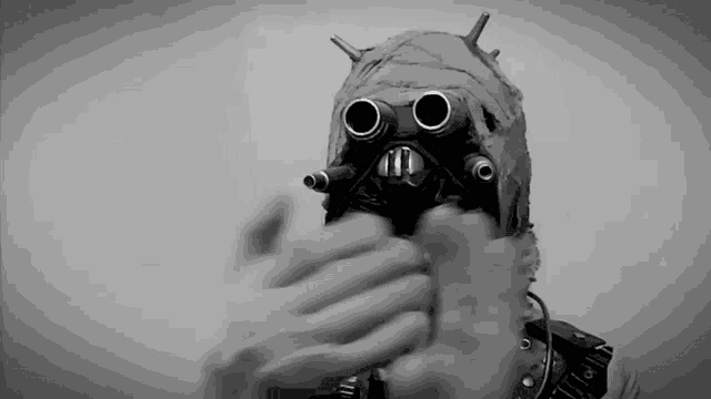 a black and white photo of a person wearing a futuristic helmet
