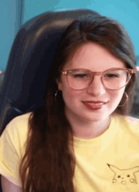 a woman wearing glasses and a yellow shirt has a pikachu on her shirt