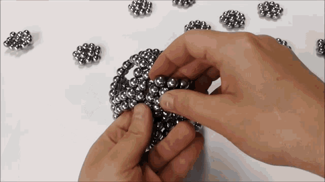 a person is holding a bunch of balls in their hands