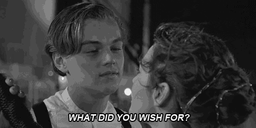 a black and white photo of a man and a woman kissing with the words `` what did you wish for '' .