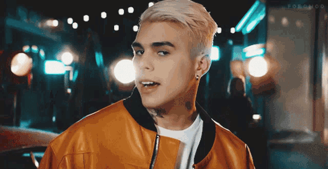 a man with a tattoo on his neck is wearing a yellow jacket and a white t-shirt