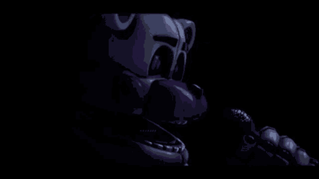 a close up of a purple and white teddy bear with a microphone in its mouth in the dark .