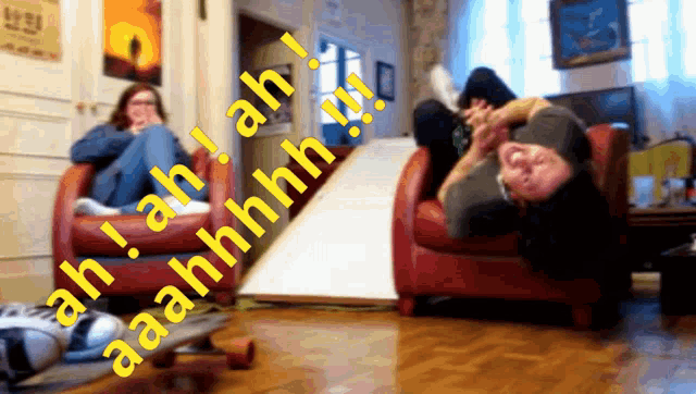 a woman sits in a red chair while a man sits in a red chair with a skateboard on the floor