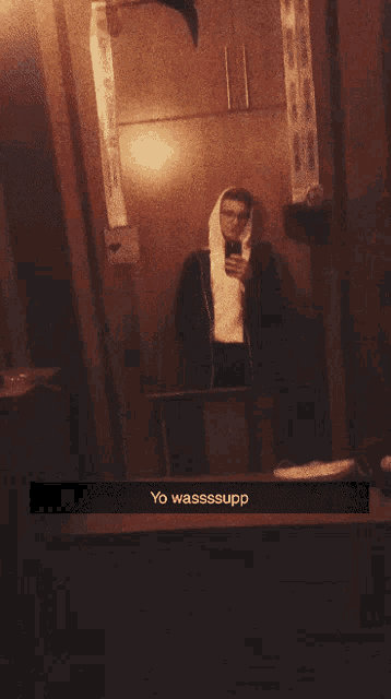 a man taking a selfie with yo wassssupp on the bottom