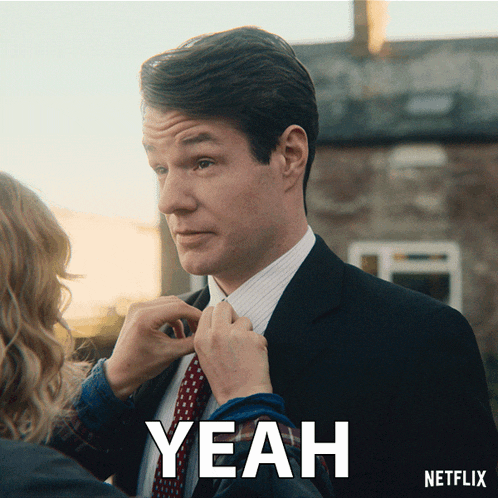 a man in a suit and tie is being helped by a woman who says yeah on the bottom