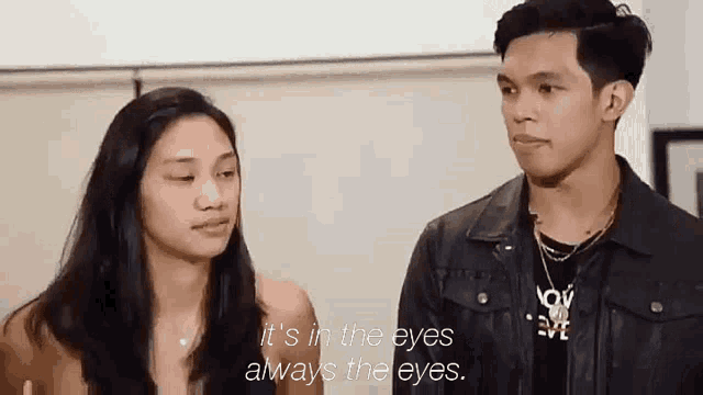 a man and a woman are standing next to each other and talking .