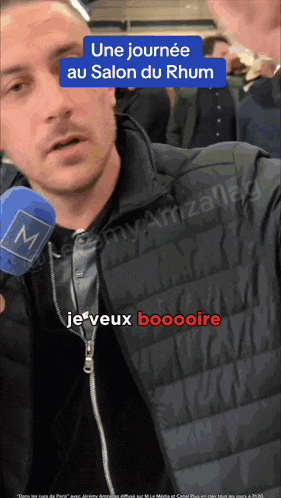 a man holding a microphone with the words une journee au salon du rhum on the top