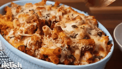 a blue casserole dish filled with pasta and cheese with the word delish at the bottom