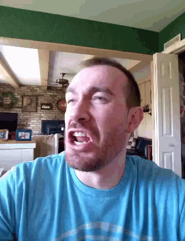 a man with a beard wearing a blue shirt with the letter p on it