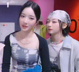 two women are standing next to each other in a room .