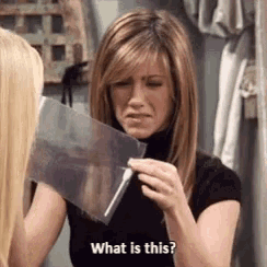 a woman is holding a piece of paper that says `` what is this '' .