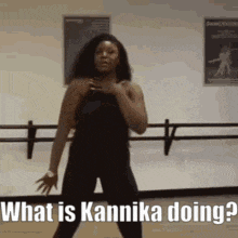 a woman is dancing in a dance studio and asking what is kannika doing ?
