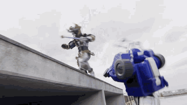a robot with a sword is fighting another robot with a blue vehicle