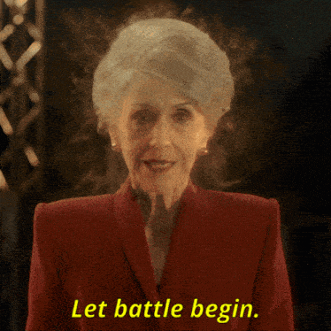 an elderly woman in a red suit says let battle begin
