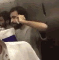 a man is sitting on a plane talking on a cell phone .