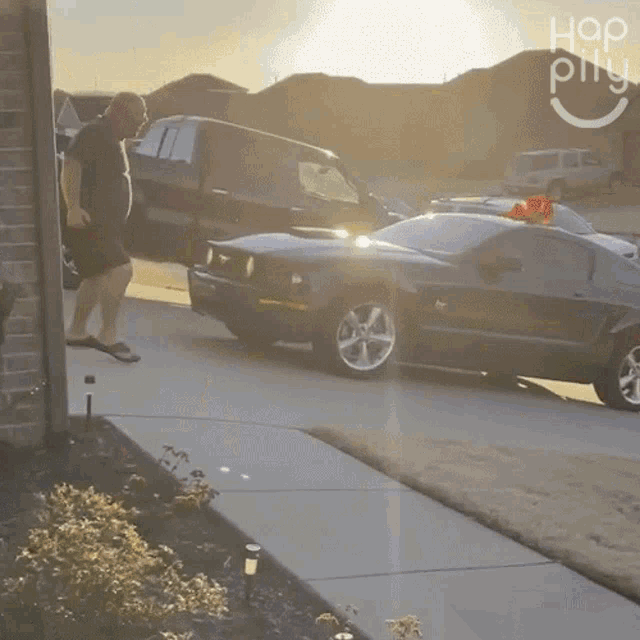 a man walks down a sidewalk next to a mustang and a truck with the word hop on the bottom