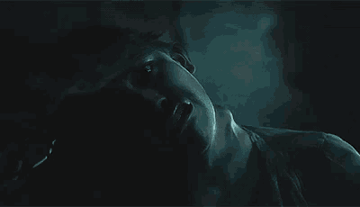 a close up of a person laying on their back in the dark .