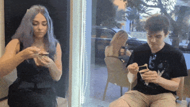 a man and a woman sit in front of a window with a sign that says south florida