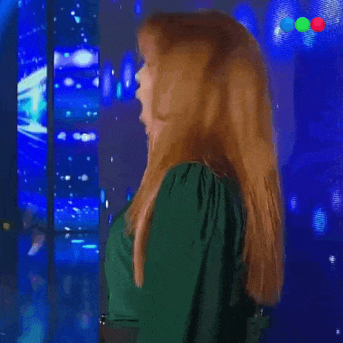 a woman is singing into a microphone and the word guau is on the bottom