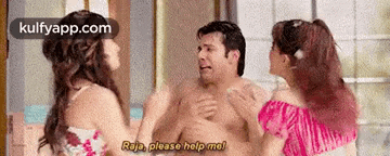 two women are standing next to a shirtless man and talking to him .