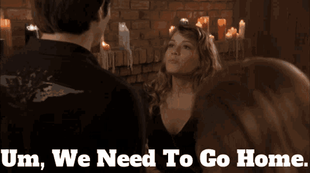 a man and a woman are standing in front of candles with the words um we need to go home on the bottom