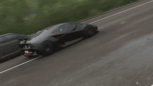 a black sports car is driving down a road with a license plate that says " aa "