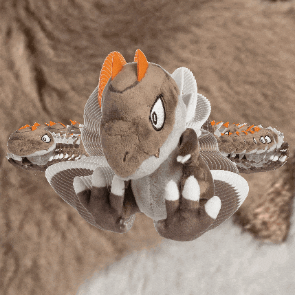 a stuffed animal that looks like a dragon with orange horns and claws