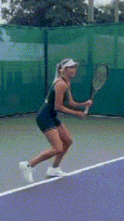 a woman in a black dress is holding a tennis racquet