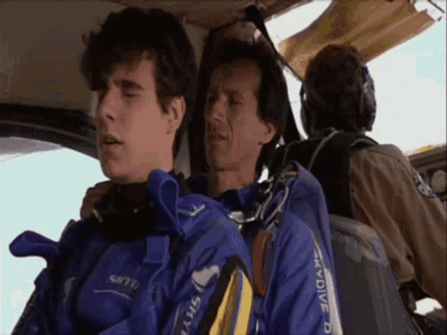 a man wearing a blue jacket that says skydive