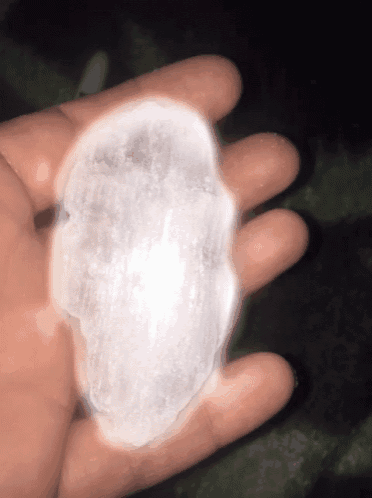 a hand holding a piece of ice that looks like a skull
