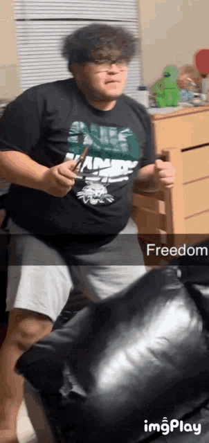 a man in a shirt that says freedom is standing on a couch