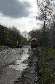 a car is driving down a muddy dirt road