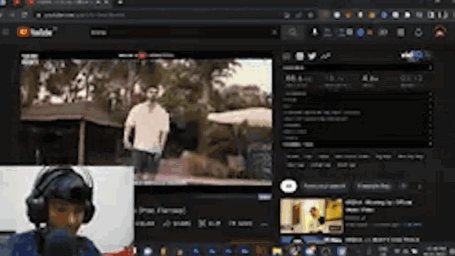 a man wearing headphones is watching a video on a laptop computer .