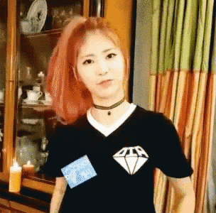 a woman with red hair is wearing a black t-shirt with a diamond on the front