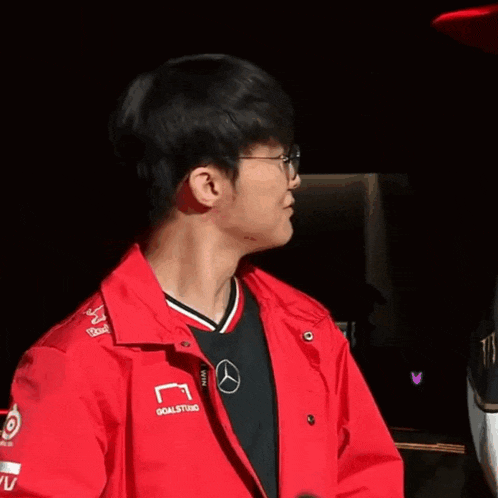 a young man wearing glasses and a red jacket with the word goalstudio on it