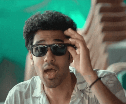 a man wearing sunglasses makes a funny face with his mouth open