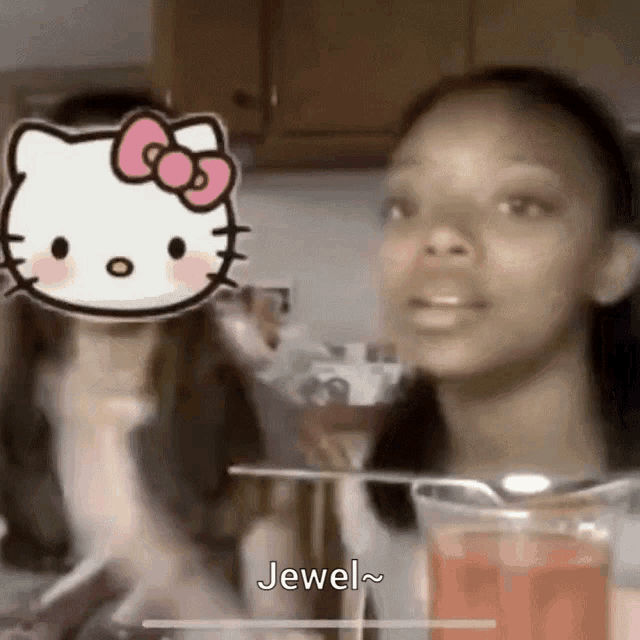 a girl with a hello kitty sticker on her face is talking to another girl in a kitchen .