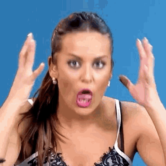 a woman in a bra is making a funny face with her mouth open .