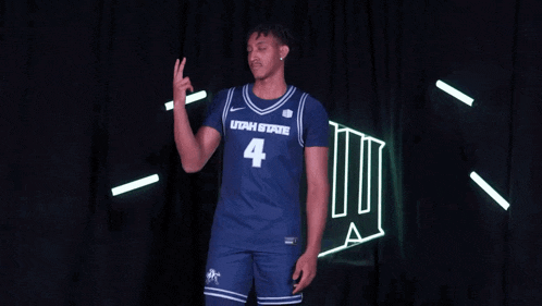 a man wearing a utah state jersey number 4 giving a peace sign