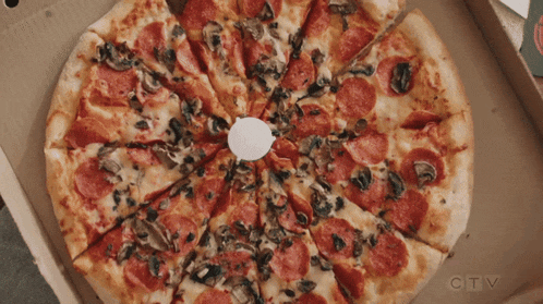 a pizza with pepperoni and mushrooms is in a cardboard box from ctv