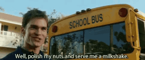 a man is standing in front of a yellow school bus .
