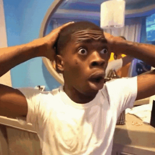 a man in a white shirt is making a funny face
