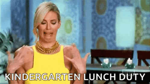 a woman in a yellow dress is making a funny face and saying `` kindergarten lunch duty '' .