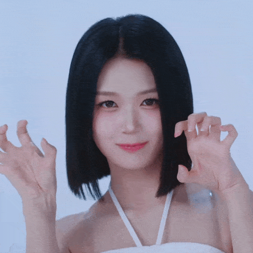 a woman with short black hair is making a cat face