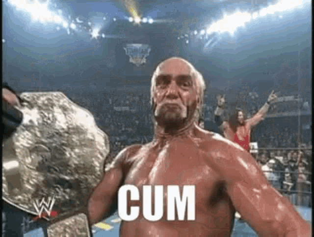 hulk hogan is holding a wrestling championship belt in a ring and says cum .