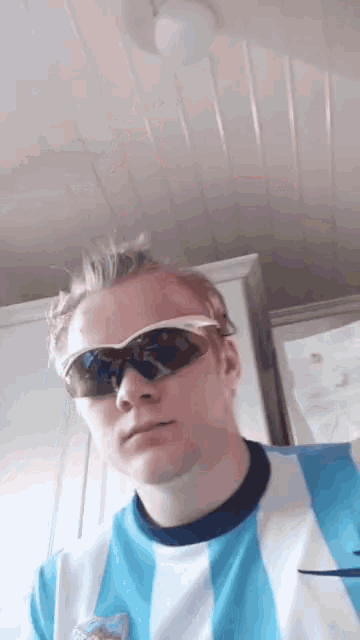 a man wearing sunglasses and a blue and white nike shirt