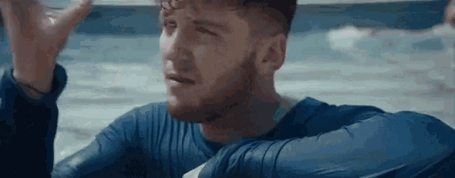 a man with a beard is sitting in a swimming pool .