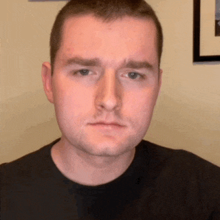 a man in a black shirt looks at the camera