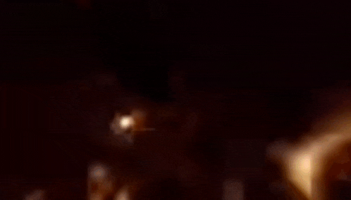 a close up of a spider web with a light coming out of it in the dark .