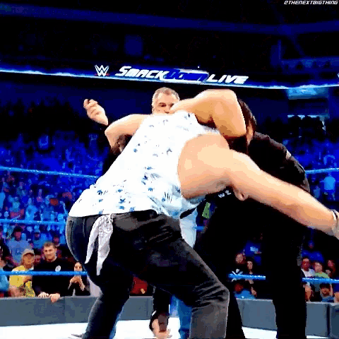 two men are wrestling in a wrestling ring with the words smackdown live in the background